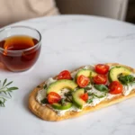 Cottage cheese flatbread served with avocado, tomatoes, and herbs.