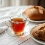 Cozy table setup with English Breakfast Tea, a porcelain teacup, and rustic bread.